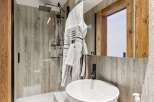 Step into luxury with this stunning bathroom featuring a sleek glass shower and a modern sink.