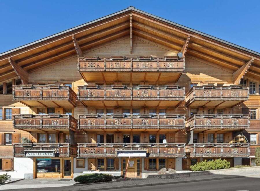 This stunning wooden chalet boasts intricate balcony designs and a charming architectural style.