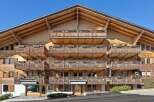This stunning wooden chalet boasts intricate balcony designs and a charming architectural style.