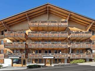 This stunning wooden chalet boasts intricate balcony designs and a charming architectural style.