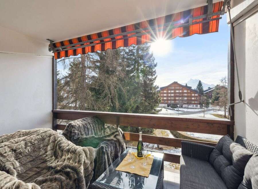Enjoy breathtaking views from this charming balcony! This property features a cozy seating area, perfect for relaxing and soaking up the sun.