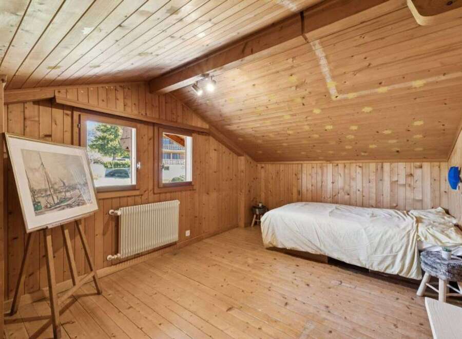 Discover the charm of this cozy bedroom with its warm wooden accents and inviting atmosphere.