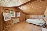 Discover the charm of this cozy bedroom with its warm wooden accents and inviting atmosphere.