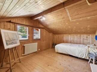Discover the charm of this cozy bedroom with its warm wooden accents and inviting atmosphere.
