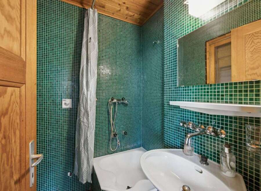 Step into this charming bathroom, featuring a unique green tile design that adds character and style.