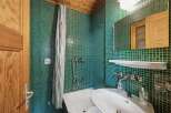 Step into this charming bathroom, featuring a unique green tile design that adds character and style.