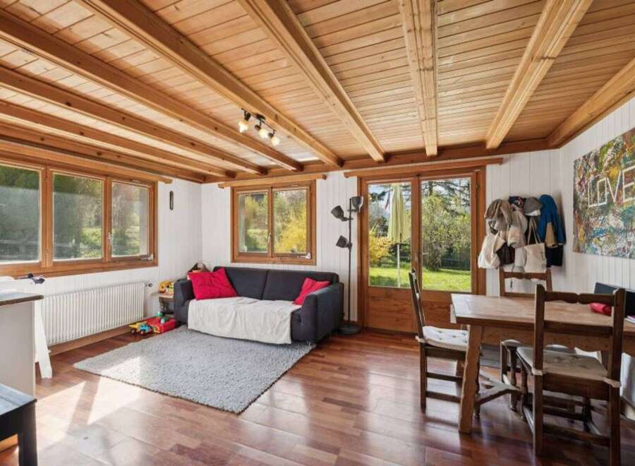 This charming property boasts a warm and inviting living space, featuring a beautiful wooden ceiling and hardwood floors.