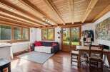 This charming property boasts a warm and inviting living space, featuring a beautiful wooden ceiling and hardwood floors.