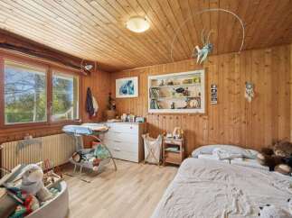 This charming bedroom features warm wooden paneling and a cozy atmosphere, perfect for a child's space.