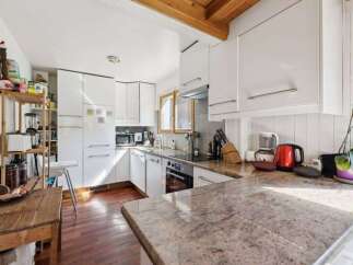 This bright and airy kitchen features modern white cabinetry, offering ample storage and a clean aesthetic.