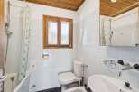 This charming bathroom features a classic design with a wooden ceiling and a window that brings in natural light.