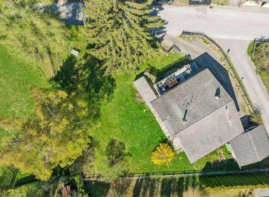 Discover this stunning property featuring a charming house with a well-maintained roof and a spacious green yard.