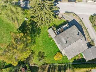 Discover this stunning property featuring a charming house with a well-maintained roof and a spacious green yard.