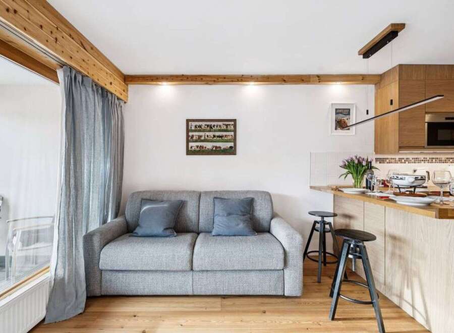 Discover this charming property featuring a cozy living space with a comfortable sofa and elegant curtains.