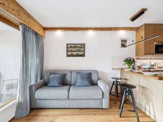 Discover this charming property featuring a cozy living space with a comfortable sofa and elegant curtains.
