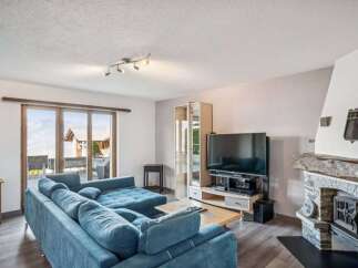 This stunning property boasts a spacious living room with a cozy fireplace, perfect for relaxing evenings.