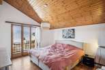 Experience the charm of this cozy bedroom featuring a stunning wooden ceiling and a comfortable bed.