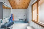 This charming bathroom features a unique wooden ceiling and light blue tiles, creating a cozy and inviting atmosphere.