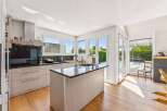 This stunning kitchen boasts a modern design with sleek cabinetry and a spacious island.