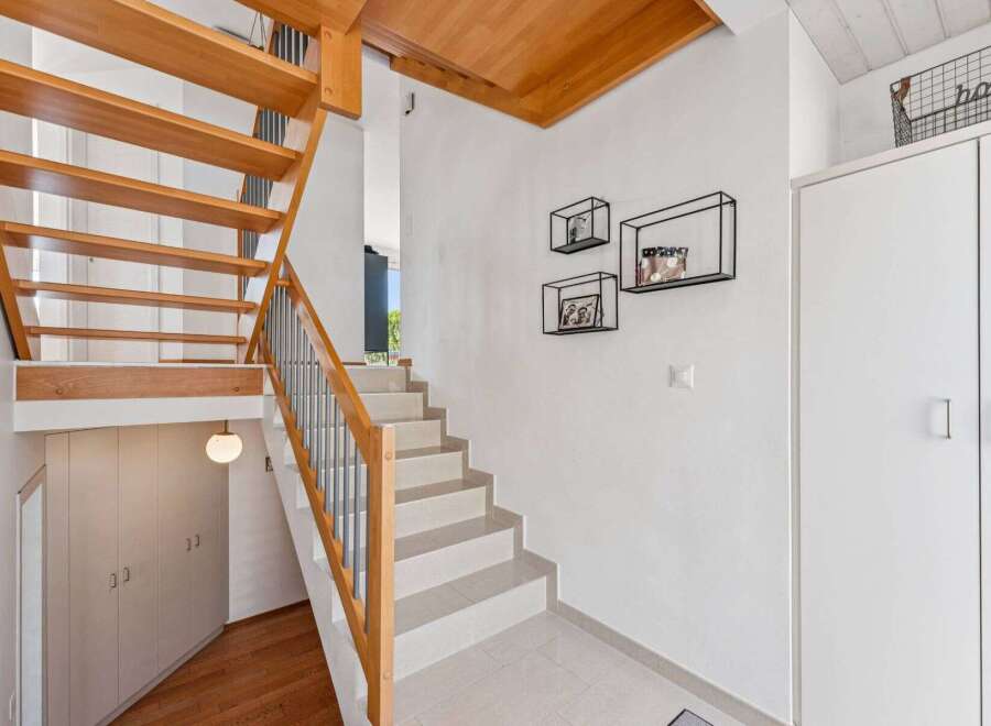 This stunning property boasts a modern staircase with wooden accents, creating a warm and inviting atmosphere.