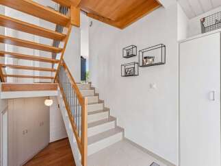 This stunning property boasts a modern staircase with wooden accents, creating a warm and inviting atmosphere.