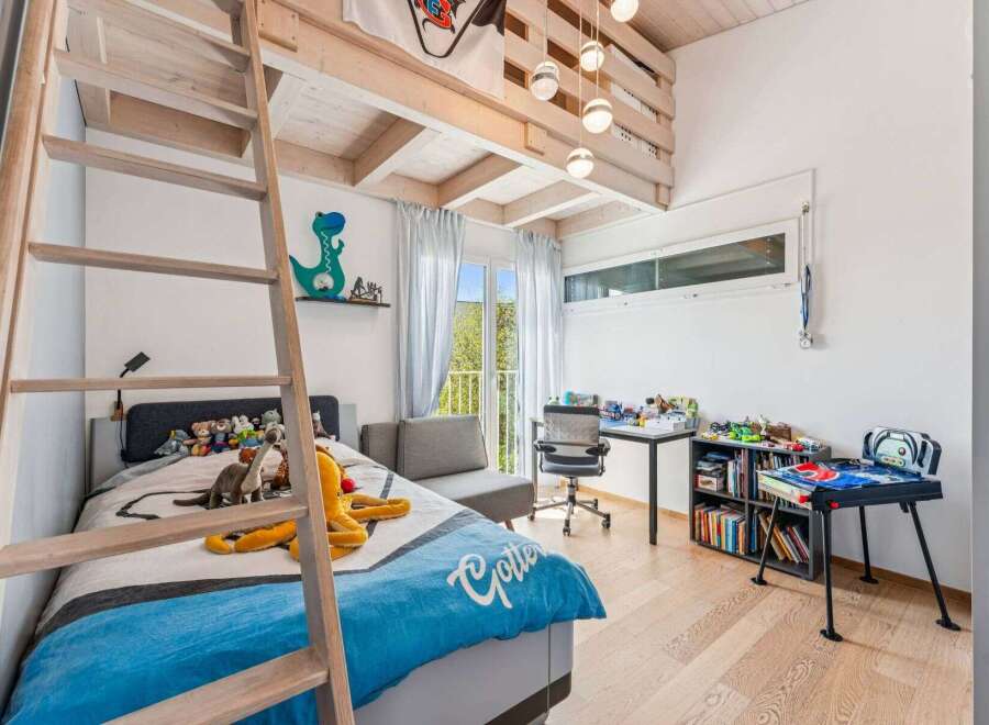 This charming bedroom features a unique loft bed design with a wooden ladder, maximizing space and adding a playful touch.