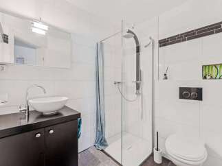 This modern bathroom features a sleek design with clean lines and bright white tiles.