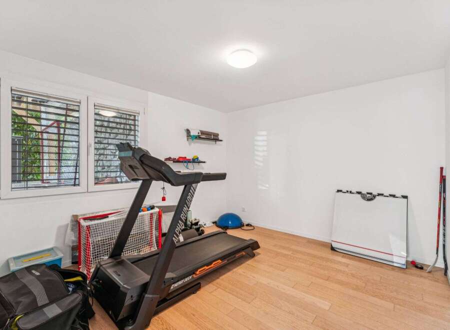 This well-lit home gym offers a variety of workout options.