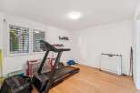 This well-lit home gym offers a variety of workout options.