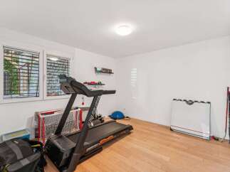 This well-lit home gym offers a variety of workout options.