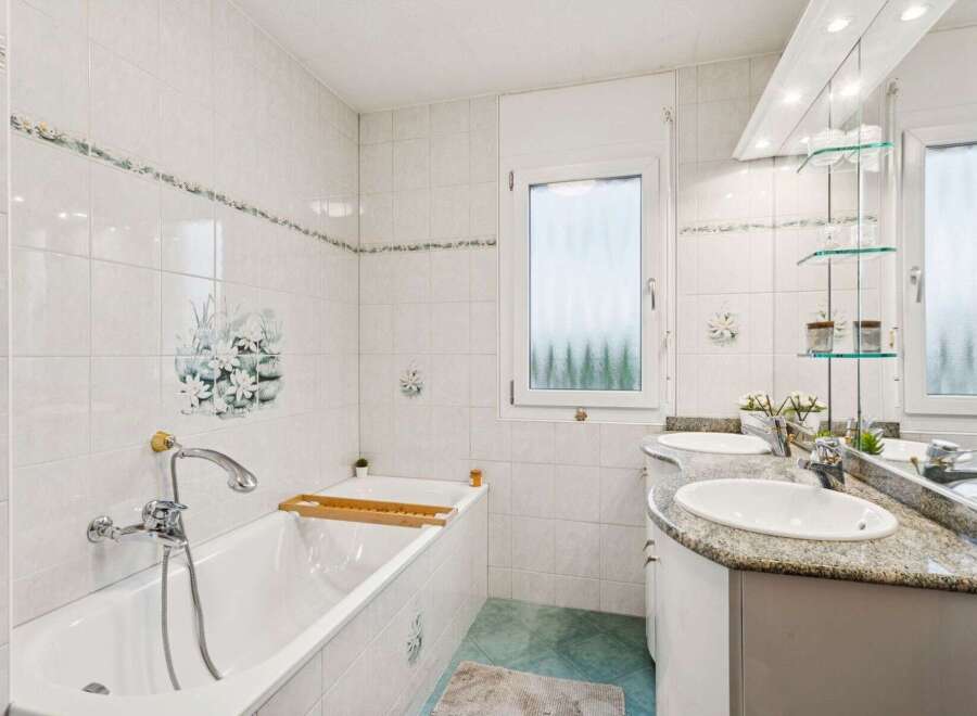 Step into this bright and inviting bathroom, featuring a pristine white bathtub and a stylish double vanity with a granite countertop.