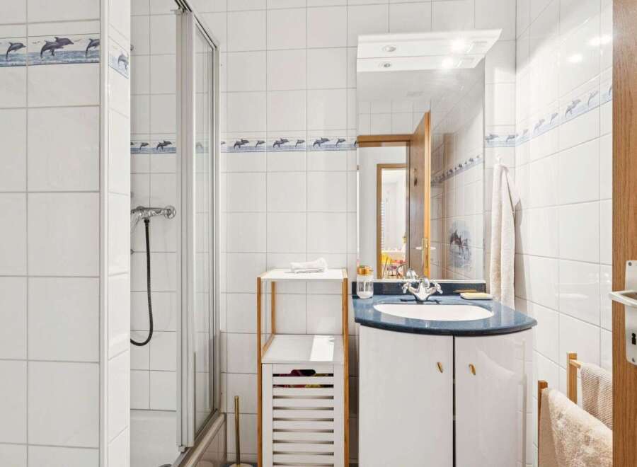 This charming bathroom features a modern design with a sleek vanity and a stylish shower enclosure.