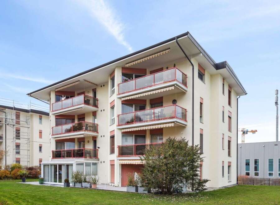 Discover modern living in this stunning apartment building, featuring spacious balconies with glass railings and awnings.
