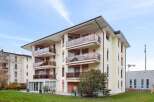 Discover modern living in this stunning apartment building, featuring spacious balconies with glass railings and awnings.