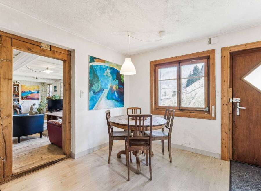 This charming property features a cozy dining area with a round wooden table and chairs, perfect for intimate gatherings.