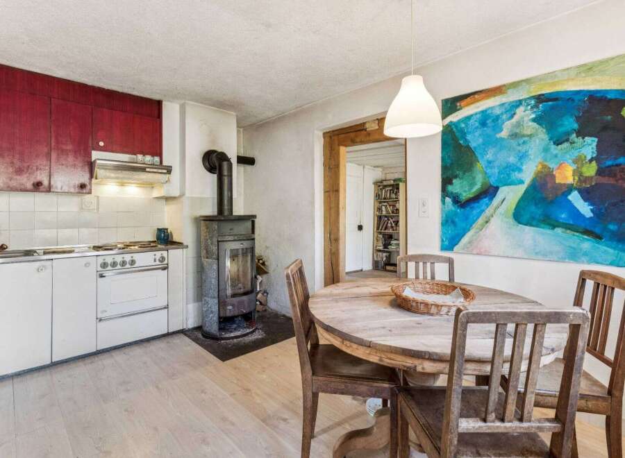 This charming kitchen features a rustic aesthetic with a wood-burning stove and a vintage-style oven.