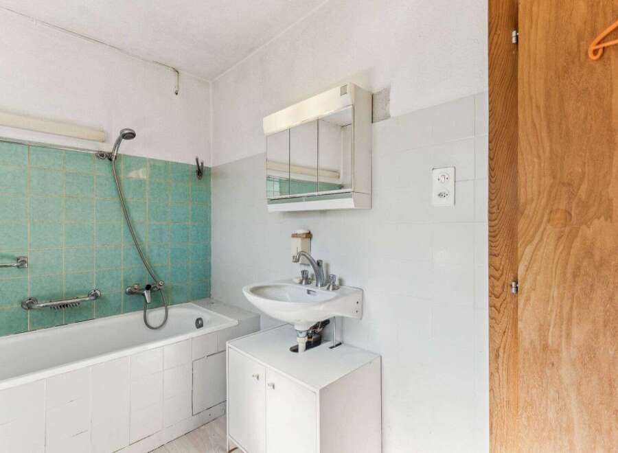 Discover this charming bathroom featuring a classic bathtub and a convenient showerhead.