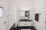 This modern bathroom features a sleek design with a black countertop and white cabinetry.
