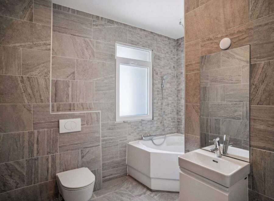 This modern bathroom features stylish tile work and a sleek design.