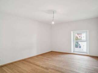 This bright and airy room features pristine white walls and beautiful hardwood floors, creating a clean and inviting atmosphere.