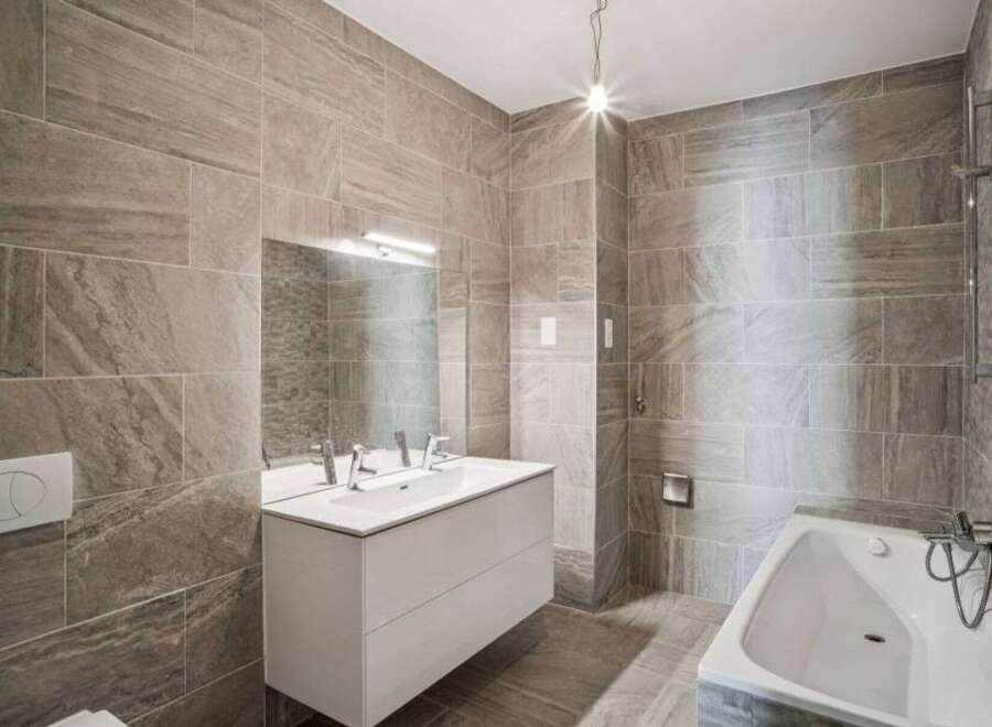 This modern bathroom features stylish tile work and a sleek, minimalist design.