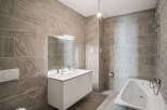 This modern bathroom features stylish tile work and a sleek, minimalist design.