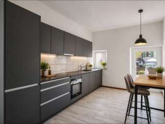 This modern kitchen boasts sleek, dark gray cabinetry and a minimalist design, perfect for contemporary living.