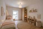 This charming bedroom offers a cozy and inviting atmosphere, perfect for relaxation.
