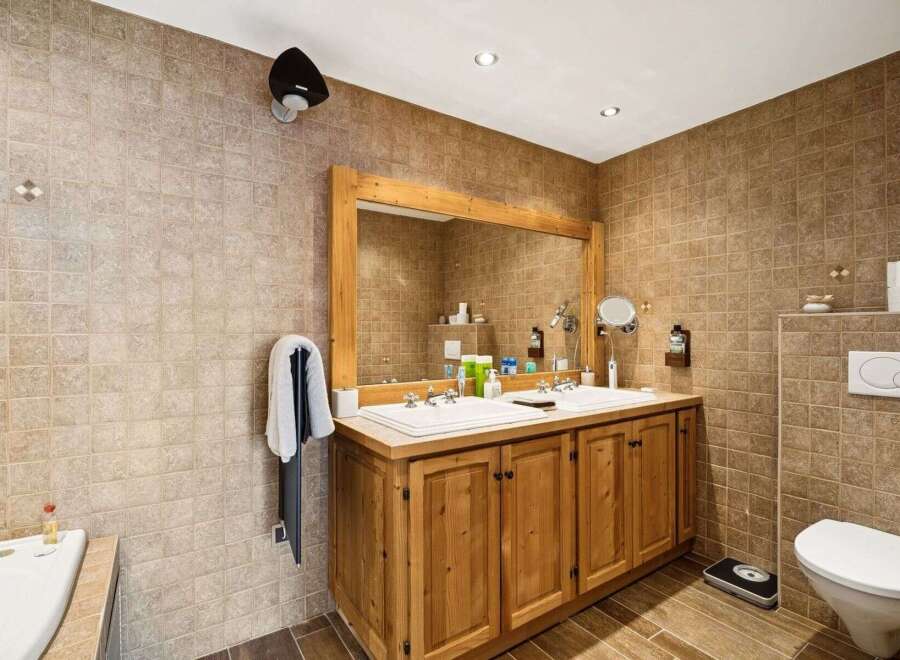 This stunning bathroom boasts a rustic charm with its wooden vanity and tiled walls.