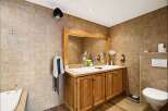 This stunning bathroom boasts a rustic charm with its wooden vanity and tiled walls.