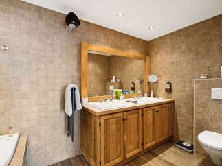 This stunning bathroom boasts a rustic charm with its wooden vanity and tiled walls.