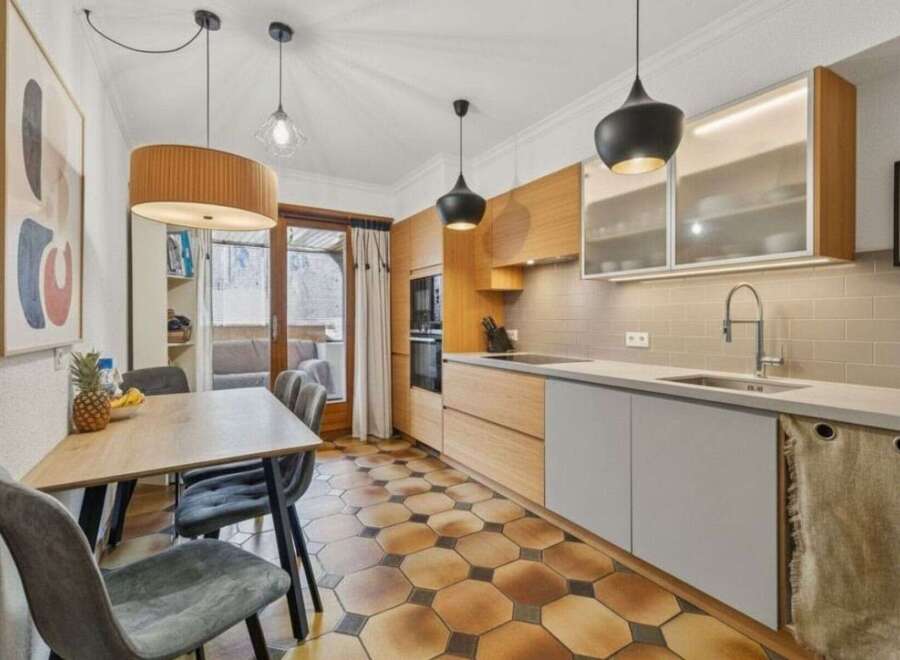 This stunning kitchen boasts a modern design with sleek cabinetry and a beautiful tile floor.
