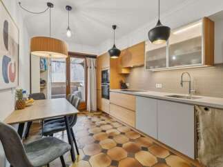 This stunning kitchen boasts a modern design with sleek cabinetry and a beautiful tile floor.