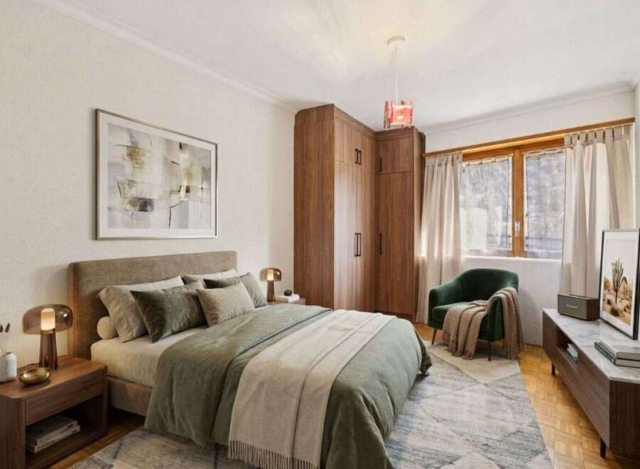 Step into this inviting bedroom, featuring a cozy bed adorned with soft bedding and pillows.